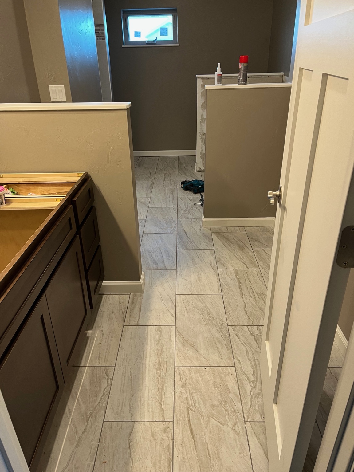 Finished large-format marble-look tile floor in a remodeled bathroom