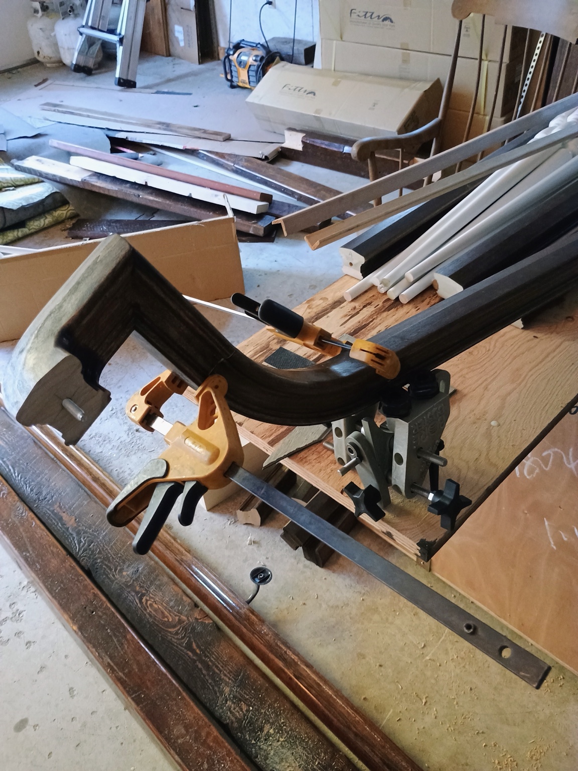 Curved wood handrail section being carefully fitted and clamped during fabrication